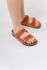 Sandalias de cuero color naranja con doble tira y detalle de costura a mano en tono contraste. Base anatómica de corcho y suela de goma antideslizante.