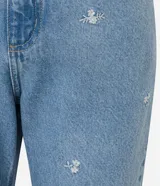 Pantalón recto cropped de jeans celeste con bordados de flores blancas.