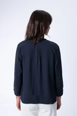 Blusa azul marino de manga larga con cuello redondo y tapeta de botones.