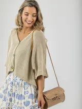 Cardigan tejido color beige, de calce oversized, con botones de madera y mangas 3/4.