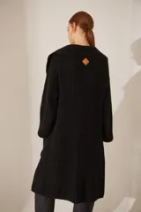 Saco largo de tejido de punto grueso color negro, con cuello shawl y bolsillos delanteros.