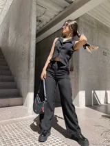 Conjunto sastrero negro compuesto por chaleco con botones y pantalón de corte recto.