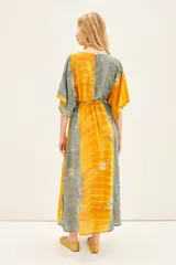 Vestido largo con estampado floral, mangas anchas al codo y ajuste elástico en la cintura.