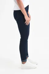 Jean chupín azul oscuro de tiro medio, con cierre de botón y cremallera, bolsillos delanteros y traseros, y dobladillo enrollado.