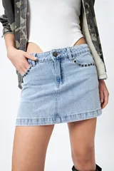 Minifalda de jean celeste con tiro bajo y detalle de tachas metálicas en los bolsillos.