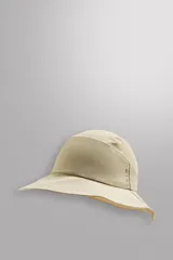 Sombrero tipo bucket color beige, confeccionado en tejido técnico con perforaciones en la copa para mejorar la transpirabilidad. Tiene ajuste elástico y ala ancha con pespuntes.