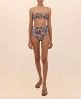 Calzón de bikini con faja cruzada y estampado abstracto en tonos marrón, azul y amarillo.