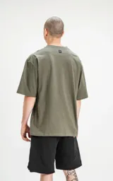 Remera verde militar de corte crop y calce oversize, con hombros caídos y cuello redondo.
