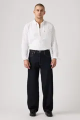 Pantalón de jean azul oscuro, corte amplio, con bolsillos delanteros y traseros.