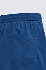 Short de baño azul con cintura elástica ajustable con cordón, bolsillos laterales y bolsillo trasero de plastrón.
