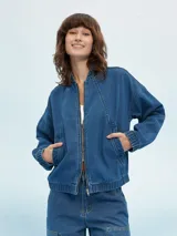 Campera de jean azul con cierre frontal, bolsillos laterales y puños elastizados.