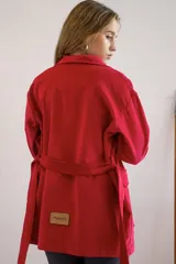Campera roja de pana con cuello camisero, corte holgado y cinturón de lazo.
