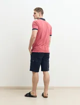 Remera polo blanca de piqué con cuello y puños en azul marino. Tiene tapeta de dos botones y bolsillo de parche en el pecho.