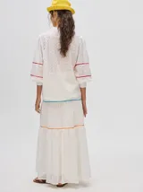 Camisa blanca de broderie de algodón, con corte holgado, mangas abuchonadas y cuello mao con cierre de 4 botones. Presenta detalle de galones con transparencias en la parte delantera y mangas, y puños fruncidos.