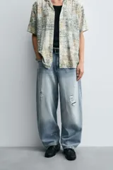 Pantalón de jean celeste con lavado gastado, corte holgado y roturas en ambas piernas.