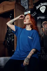 Remera azul con estampado en tinta blanca y dorada con la frase "No Mercy Club Quality Matters Since 19". Corte oversized más amplio en la parte trasera.