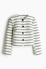 Chaqueta corta con cuello redondo, cierre frontal con botones negros, pinzas en el busto y abertura decorativa en los puños. Forrada.