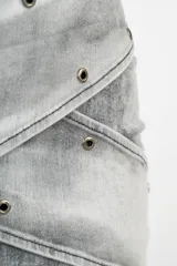 Minifalda gris de jean con diseño cruzado y tachas plateadas.