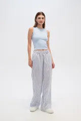 Pantalón de algodón a rayas verticales celestes y blancas, de corte holgado y tiro alto.