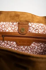 Bolso tipo tote de gamuza vegana color camel, con asas de mano y logo grabado en el frente.