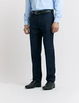 Traje de vestir color marrón topo, compuesto por saco de dos botones con solapa de muesca, dos bolsillos delanteros con solapa y un bolsillo superior. Pantalón de vestir con corte recto y bolsillos laterales. Incluye camisa blanca y corbata azul con lunares blancos.