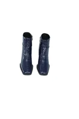 Botines de cuero vacuno azul marino con efecto croco brillante. Tienen caña media, cierre lateral y tacón bloque negro brillante de aproximadamente 7 cm.