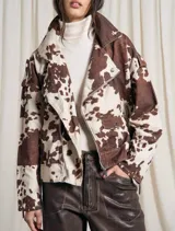 Campera de corte oversized, con estampado de vaca en tonos marrón y blanco, ideal para un look audaz.
