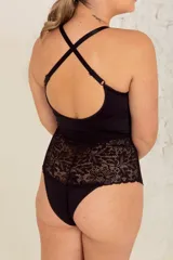Body negro de lycra y puntilla elastizada, con tiras cruzadas en el frente, breteles elásticos regulables y broche en la entrepierna con fundillo de algodón.