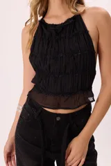 Top halter negro de gasa con volados y amarre regulable en espalda.