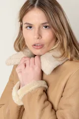 Campera marrón de cuero ovino con cuello y puños de piel sintética color crema, cierre frontal con cremallera y bolsillos laterales.