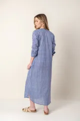 Vestido largo camisero a rayas verticales azules y blancas, con cuello mao, abotonadura frontal completa, mangas largas y bolsillos laterales.