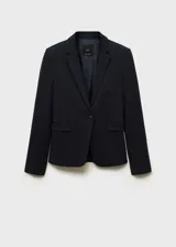 Chaqueta negra con cuello de pico con solapa y cierre de botón en la parte delantera. Tiene manga larga con puños abotonados, diseño recto, estilo traje y dos bolsillos de solapa en la parte delantera.