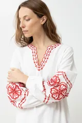 Túnica larga color crudo con bordados rojos en cuello, mangas y ruedo.