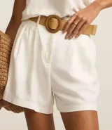 Short clochard azul marino de viscolino con trabillas en la cintura, cinturón con hebilla de madera y pliegues.