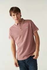 Remera cuello polo gris melange de manga corta, corte regular, con detalles de doble línea blanca en cuello y mangas, logo estampado en el pecho y confección en algodón.