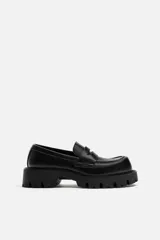 Mocasín negro de cuero con antifaz, horma cuadrada y suela track con volumen.