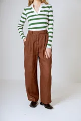Pantalón negro de corte ancho y tiro alto, con pinzas en la cintura y bolsillos laterales.