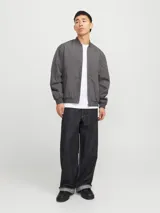 Campera bomber liviana color gris, de manga larga con cuello baseball y fit cómodo. Diseño con cierre frontal de cremallera, bolsillos delanteros funcionales y puños de canalé.
