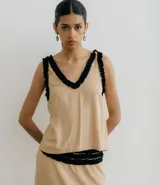 Musculosa color beige con escote en V y detalle de volados negros en escote y sisas.