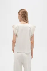 Blusa sin mangas de lino y viscosa, color blanco con laterales en beige, corte holgado y cuello en V.