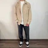 Sobrecamisa color beige de pana con cuello clásico, cierre con botones y bolsillo de parche en el pecho. Corte recto y mangas largas con puños abotonados.