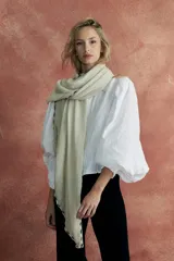 Pashmina color crudo con bordado de líneas negras en los bordes y terminación con flecos.