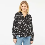 Blusa negra con lunares blancos, de corte holgado, cuello camisero y mangas 3/4.