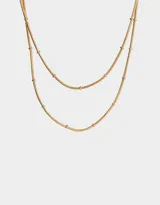 Collar corto dorado con doble cadena fina tipo snake y pequeñas bolitas decorativas.