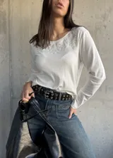 Remera blanca de algodón con cuello redondo y bordado con calados en el escote.