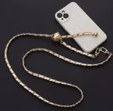 Correa para celular dorada con cadena entrelazada con cuero sintético blanco, con terminales doradas y accesorio para sujetar a la funda del celular.