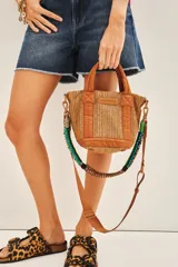 Cartera tote mini color negro, confeccionada en tejido tipo rafia. Cuenta con bolsillos internos, dos correas desmontables y abertura superior con cierre.