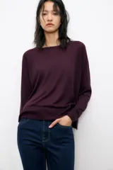 Jersey de punto color verde oliva, con cuello redondo y manga larga. Tiene bajo con aberturas laterales y acabados en rib.