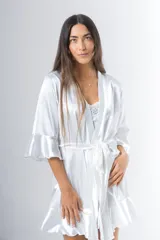 Bata corta color blanco de satén elastizado, con mangas tres cuartos con volados y lazo para atar en la cintura.