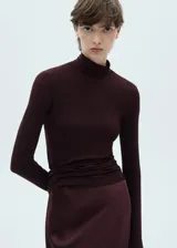 Camiseta de cuello alto color borgoña, de tejido de punto fino y corte ajustado.